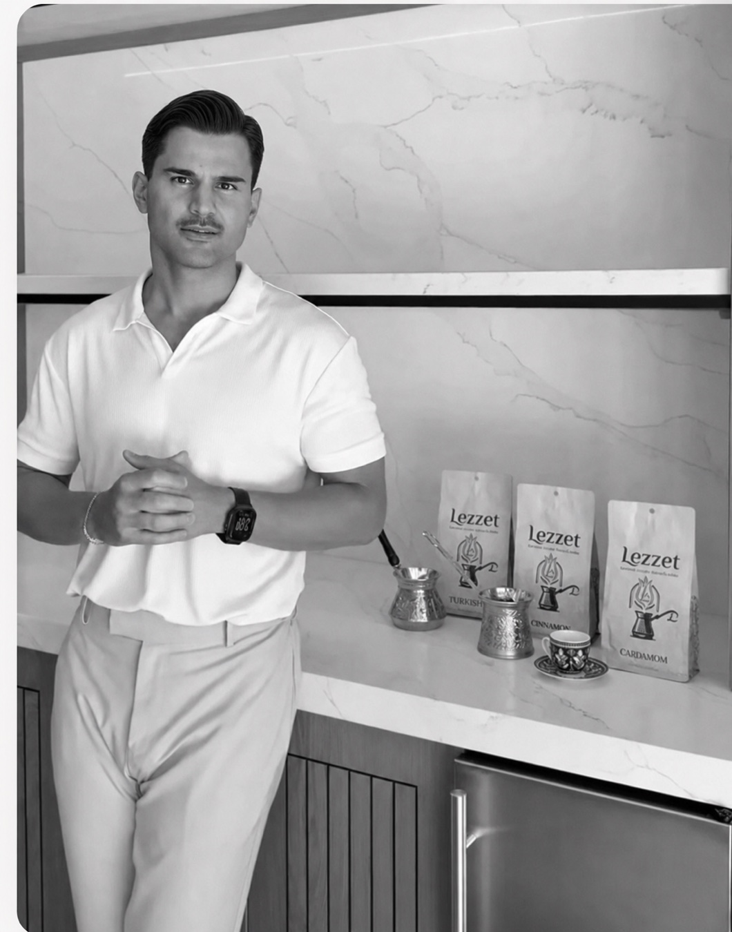 Muhammed Çam standing beside Lezzet Turkish coffee bags, a cezve, and a Turkish coffee cup.